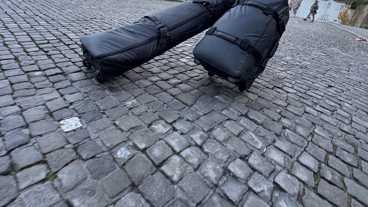 Endeavor Expedition Roller Bag and board bag rolling over cobblestones