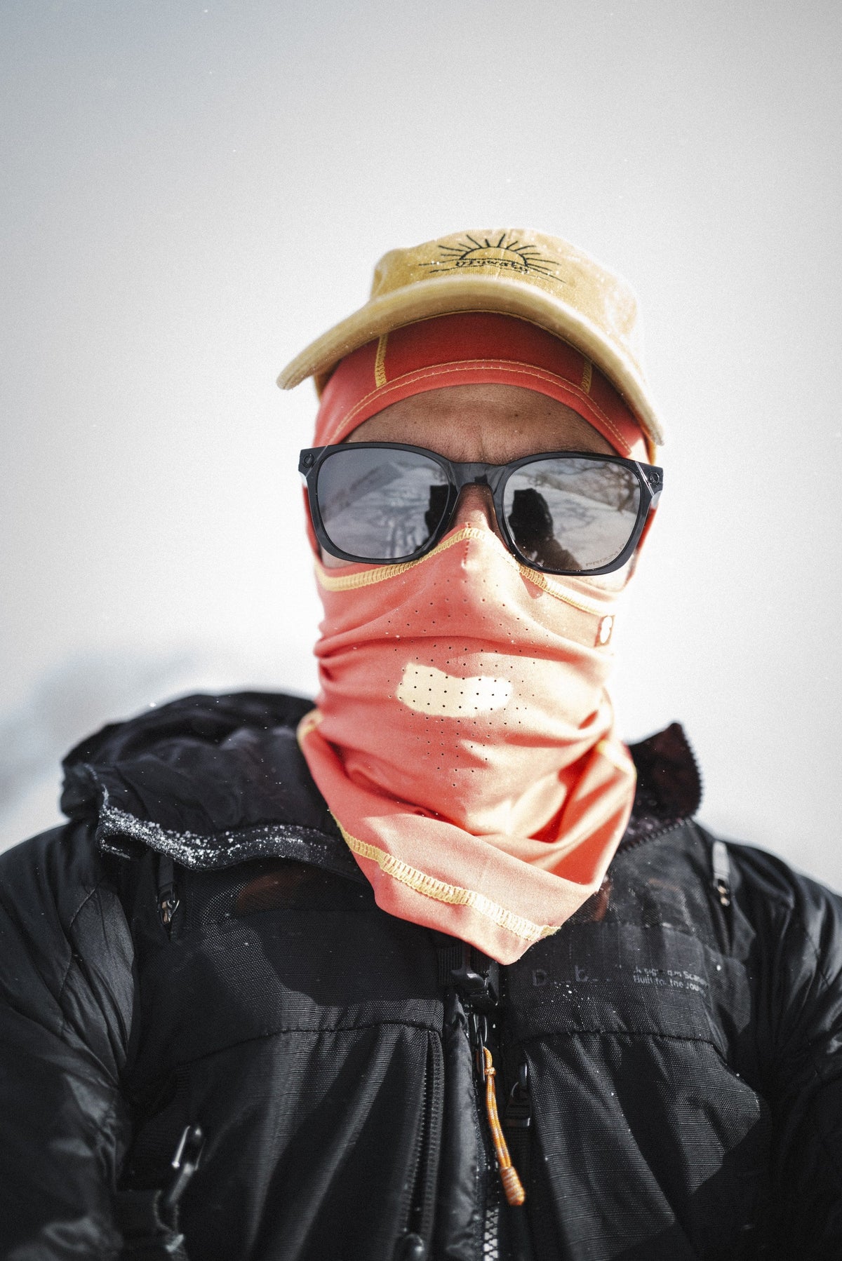 Airhole Airtube Ergo Hyper Hole neck gaiter in Orange on snow, turned yellow at the laser holes