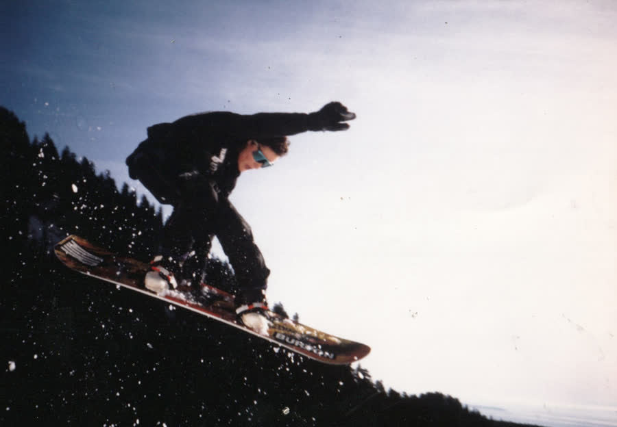 Snowboarder grabbing in the air on a snowy hill