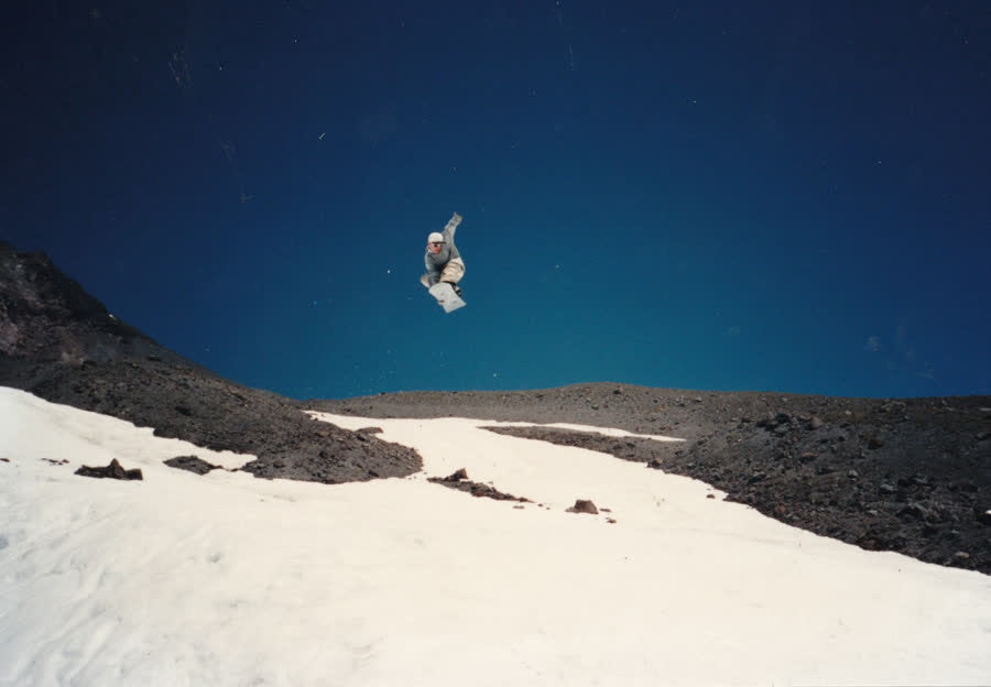Snowboarder in the air over an alpine snowfield