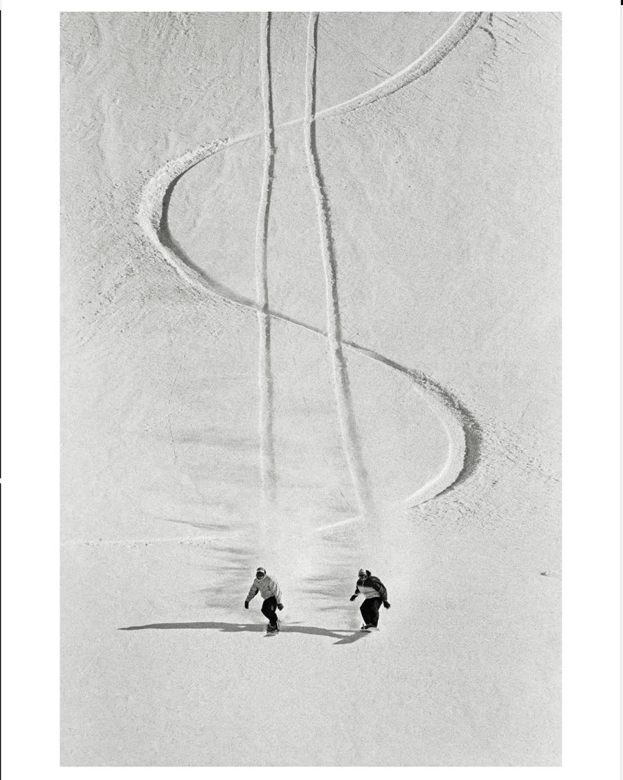 Black-and-white photo of two sets of S-turn tracks in powder