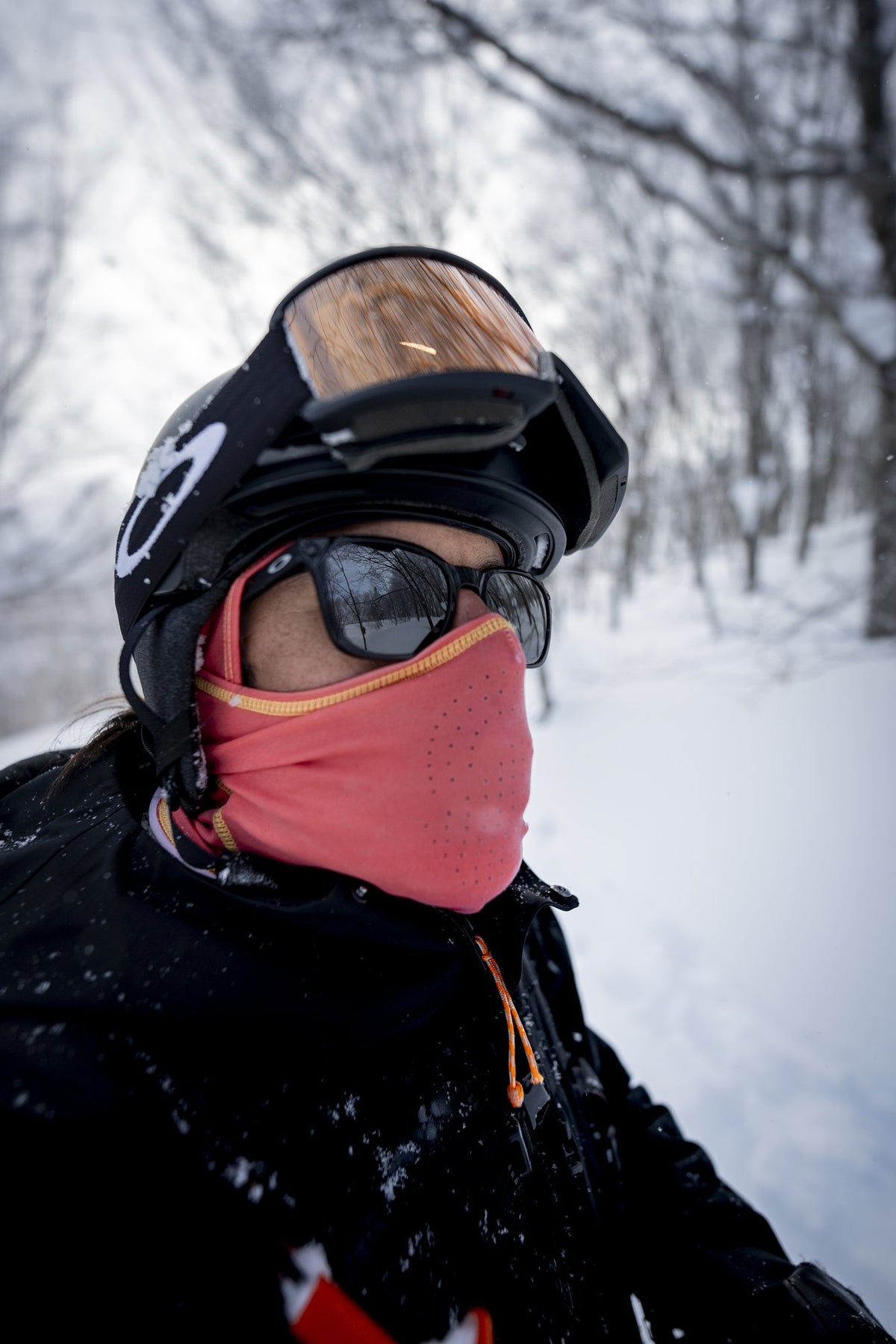 Rider in a Hyper Hole neck gaiter in the trees, Japan. Photo: Mason Mashon