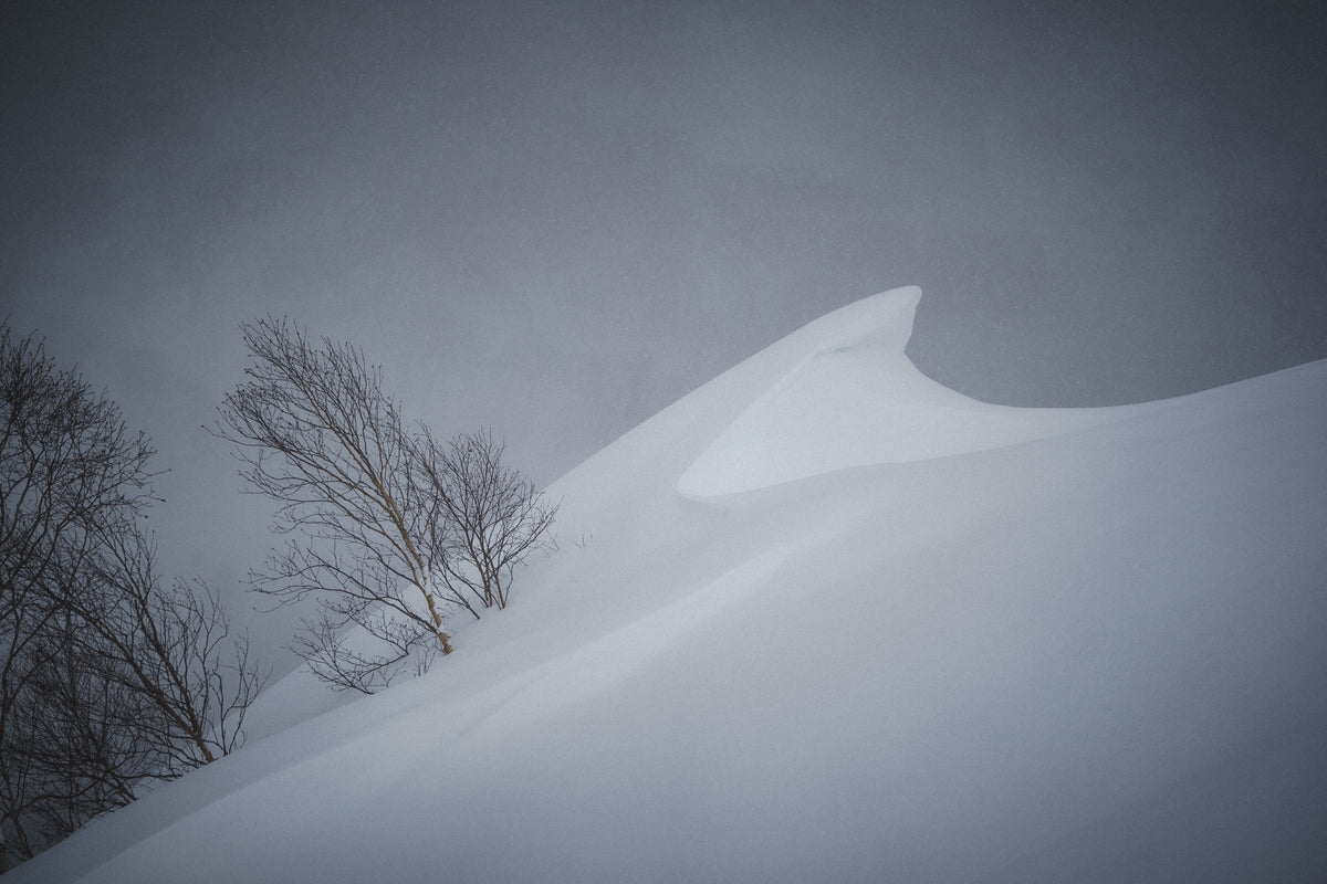 Wind-carved lip of snow in a whiteout